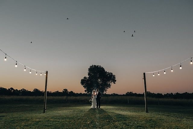 Amazing sunset photography at Albion on Swan for a wedding with birds flying over head and the lights illuminating the outdoor area