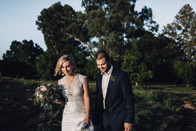 Bride & Groom walk through the field together