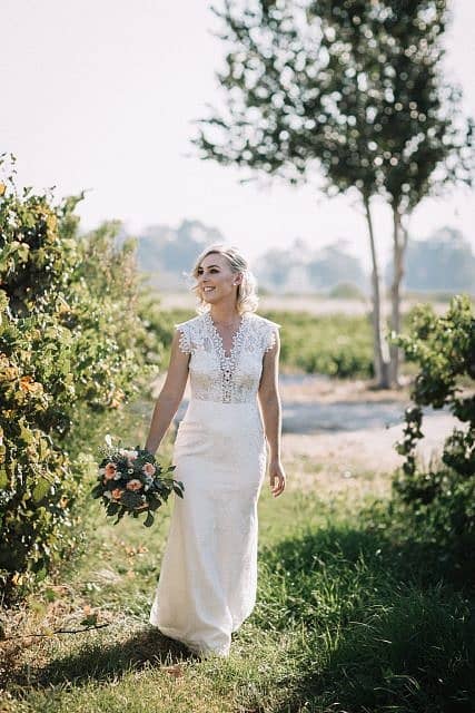 bride walking through the vines in swan valley