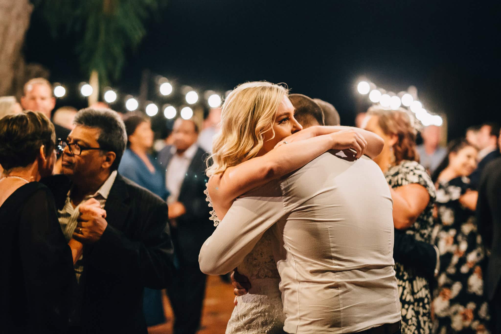 While dancing a bride and groom lovingly hug each other