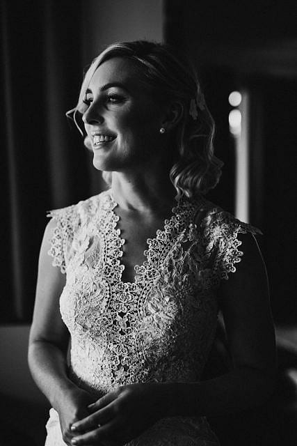 Bride smiles elegantly for a picture before going to ceremony